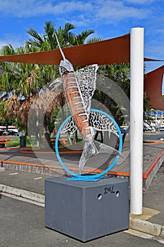 Fish Sculpture resembling swordfish outside of Noumea Wet Market with shade cover & green trees in the background