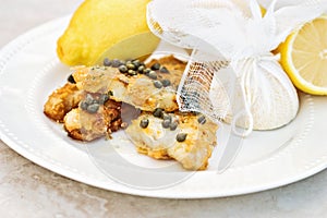 Fish Served With Lemons Tied in Cheesecloth photo