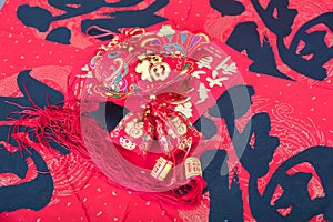 Fish-shaped ornaments and other related items on the Chinese New Year CoupletsFish-shaped ornaments and red envelopes on red sprin