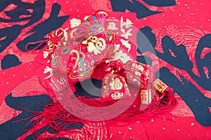 Fish-shaped ornaments and red envelopes on red spring couplets background.The Chinese characters on the spring couplets mean `happ