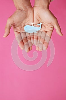 Fish-shaped paper, empty on hand, isolated from pink background