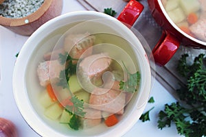 Fish soup with potatoes, carrot, and parsley