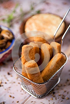 Fish sticks in a metal basket and spanish omelet