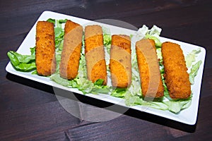 Fish sticks on wooden tray on visas from above