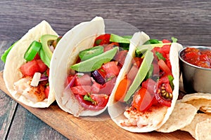 Fish tacos with watermelon salsa and avocados close up side view