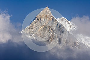 Fish Tail Summit Machapuchare surrounded by rising clouds in Himalayas