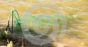 Fish tank in the water on the river bank