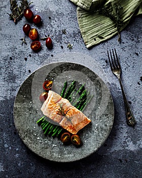 fish, vegetables and herbs on a plate next to a fork