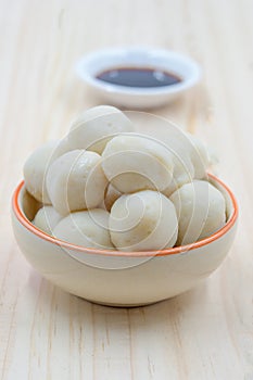 Fishballs in ceramic bowl on wooden background.