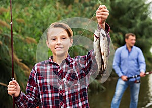 Fisher boy showing catch fish