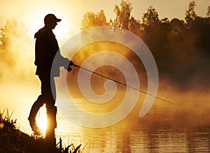 Fisher fishing on foggy sunrise