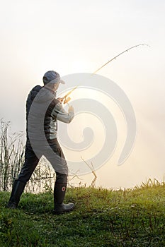 fisher with fishing rod fishing