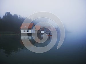 Fisher in front of boat houses at Grosser Alpsee in the Allgaeu in Bavaria