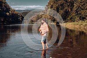 Fisher man fishing with spinning reel. Fly rod and reel with a brown trout from a stream. Fishing in river.