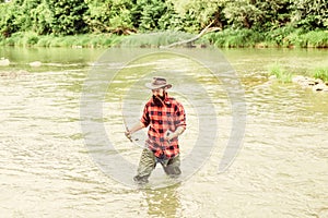 Fisher masculine hobby. Fish on hook. Brutal man stand in river water. Man bearded fisher. Fishing requires to be