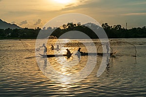 Fisher men fishing on a fishing boat in river in Mekong Delta on floating water season at sunset