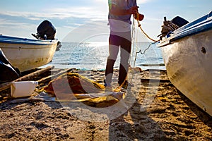 Fisher pile up fishing net at sandy beach