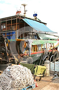 Fisherman repairs his boat in the harbor,Hongkong