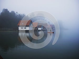 Fisherboat in front of boat houses at Grosser Alpsee in the Allgaeu in Bavaria