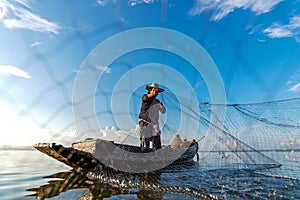 Fisherman action when fishing net  on lake in the sunshine morning outdoors on the boat. Agriculture Industry,