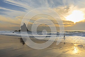 Fisherman in adraga beach at sunset