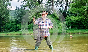 Fisherman alone stand in river water. Man senior bearded fisherman. Hobby sport activity. Pensioner leisure. Fish