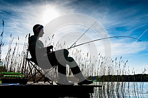 Fisherman or Angler at lake in Sunrise backlit