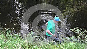 Fisherman angler man clean private lake water from plants and rubbish. 4K