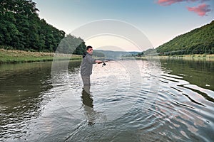 Fisherman angling on the river. Beautiful view over the river Dniester and riverbank