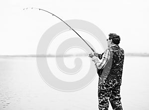 Fisherman angling on the river photo
