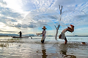 Fisherman with asian boy and girl action when fishing net playing outdoor on river and lake in the morning sunrise.