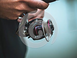 The fisherman with a baitcasting reel close-up photo