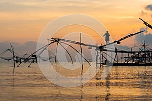 Fisherman on bamboo machinery in the morning