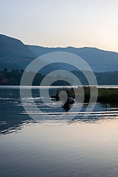 A fisherman in a beautiful landscape of a lake