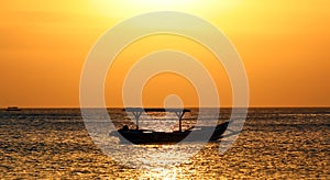 Fisherman boat in Bali, Indonesia during golden sunset. Ocean and sky looking like gold. photo