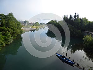 Fisherman in a boat on a calm mountain river, town Plav, Montenegro