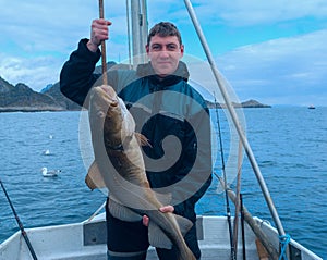 Fisherman on boat with codfish photo