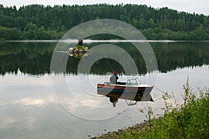 Fisherman on the boat early morning on the river in Northern Karelia