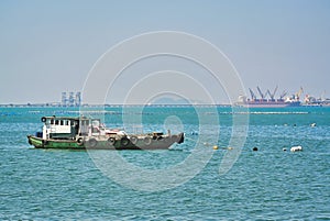 Fisherman Boat Floating in the Sea with Sea Port in Distant