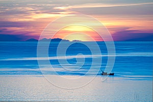 Fisherman on boat in the morning with sunrise