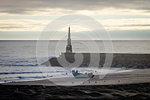 Fisherman and Boat near Beacon at the Ocean