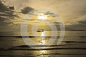 Fisherman boat in scintillation sea under golden sky