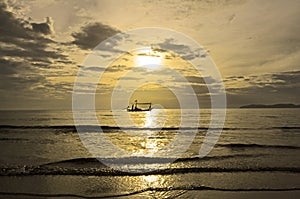 Fisherman boat in scintillation sea under golden sky photo