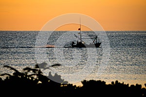 A fisherman boat silhouette at the sunrise time