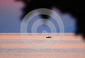 Fisherman in boat at sunset