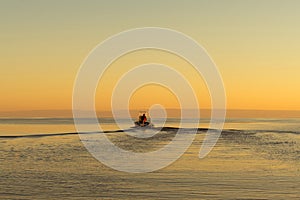 Fisherman on boat at the sunset. Beautiful sunset with the fishing boat. Fishing motor boat with angler. Ocean sea water wave