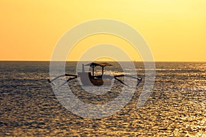 Fisherman boat without fisherman at Bali, Indonesia during sunset at the beach. photo