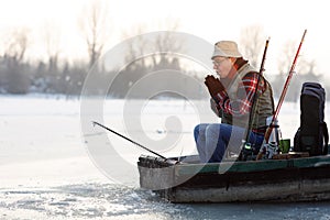 Fisherman in boat worming hands photo
