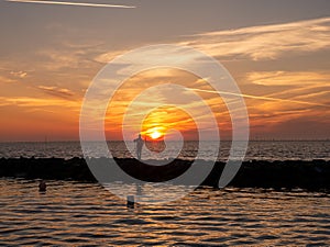 Fisherman on breakwater at sunrise, Waddensea, Hornum, Sylt island, North Frisia, Schleswig-Holstein, Germany