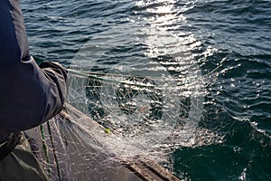 Fisherman bringing back net in a boat